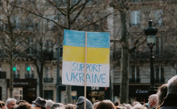 large group of people holding banner on supporting ukraine